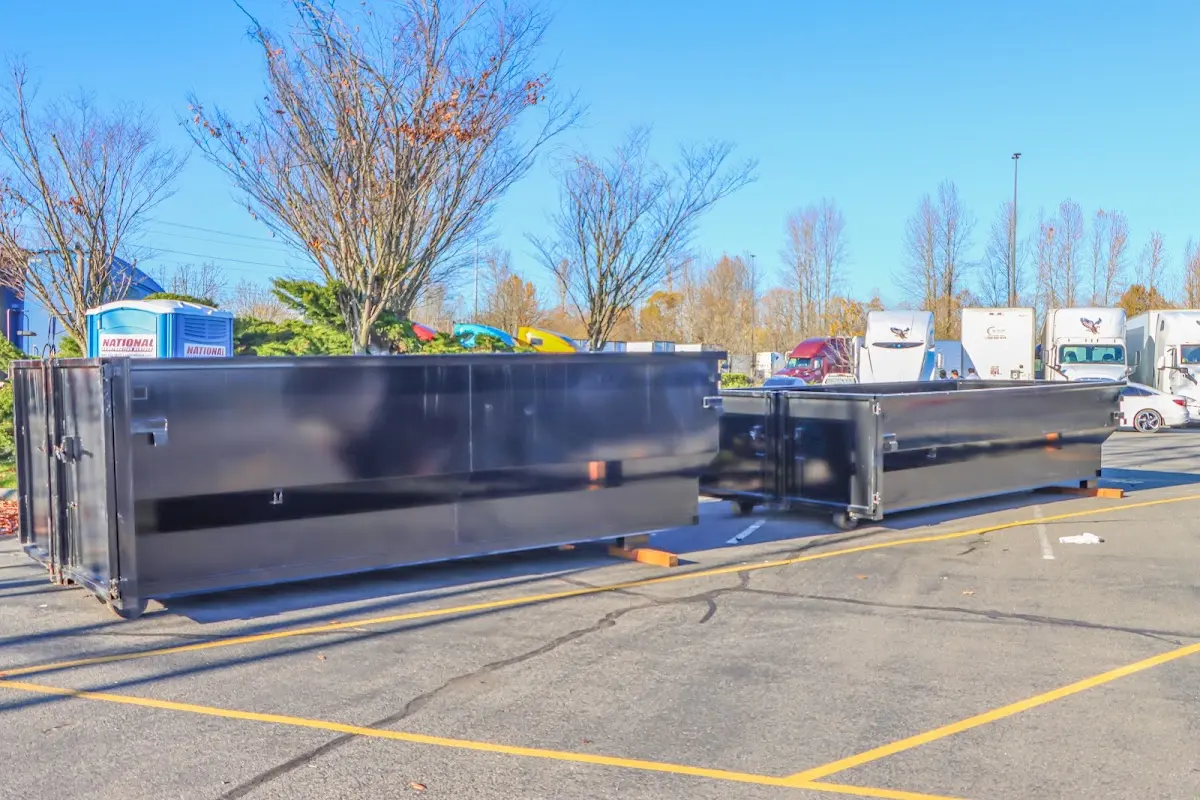 Professional dumpster rental service with roll-off container on residential driveway in Adams